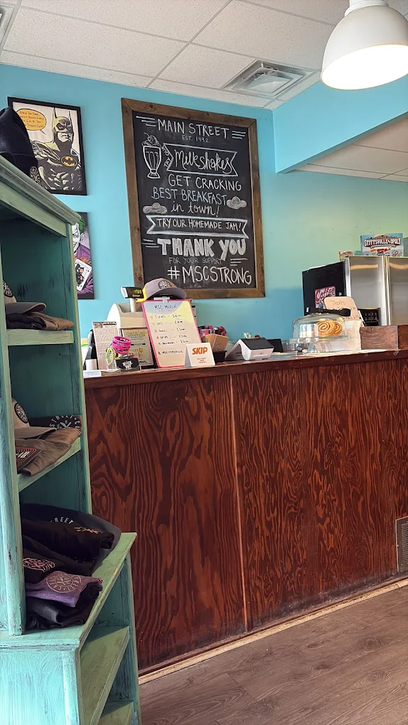 Counter with chalkboard, teal walls, and merchandise shelf